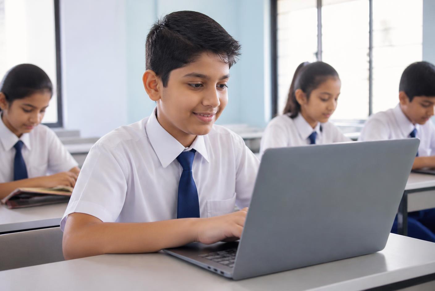 A school student coding on a laptop in class